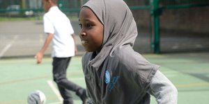 Girl in Hijab running in a playground
