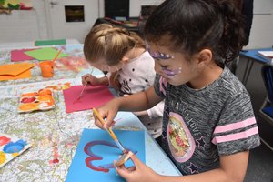 Two young girls painting in a class room