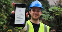 Worker from Worker Feedback Club holding phone