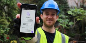 Worker from Worker Feedback Club holding phone