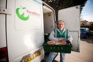 Man holding a crate of fresh bread