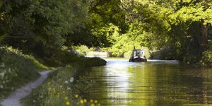 Sun shining over a canal with a boat