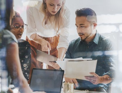 Three people looking at a file and discussing it