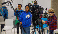 Three children using camera equipment