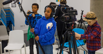 Three children using camera equipment