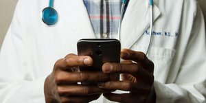 Doctor typing on phone