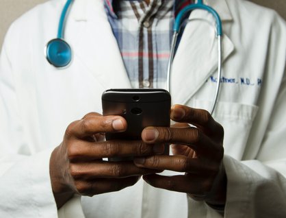 Doctor typing on phone