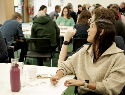 Two people sitting back to back having a conversation